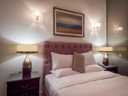 a bedroom with a bed with two night stands and two lamps at 1920s Boutique Hotel and Restaurants in Cairo