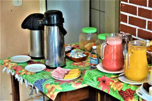 a table with a table cloth with food and juice at Pousada do Imperador in Paraty