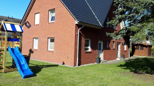 a blue slide in front of a brick house at Ferienhaus "Seestern" in Ostseebad Karlshagen