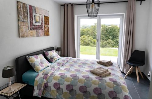 ein Schlafzimmer mit einem Bett und einem großen Fenster in der Unterkunft Villa WallAnn in Morbach