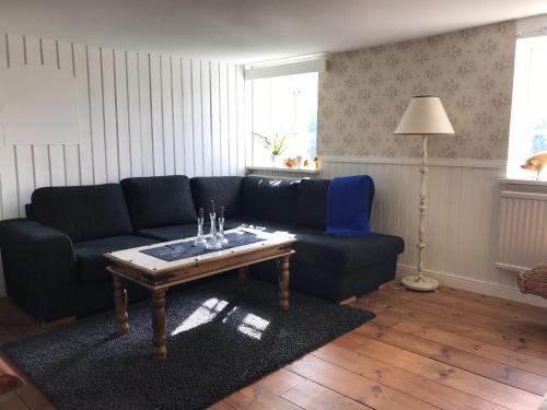 a living room with a blue couch and a coffee table at Husargårdens Bed & Breakfast in Sjöbo