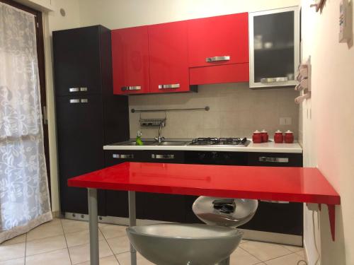 kuchnia z czerwonymi szafkami i czerwonym blatem w obiekcie Casa MALÙ 2 w mieście Latina