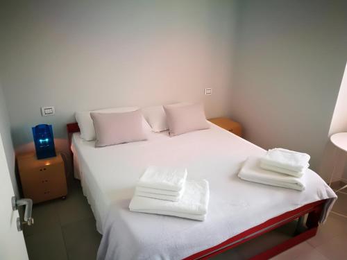 a bedroom with a bed with white sheets and towels at Bellavista Eremitaggio in Torri del Benaco