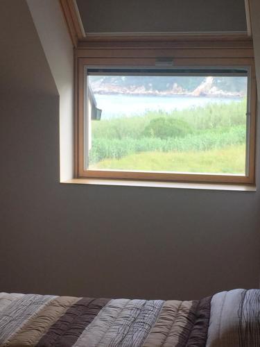 a window in a bedroom with a bed in front of it at Porto de Espasante -Severino Blanco in O Porto de Espasante