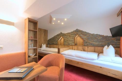 Habitación con 2 camas y mesa. en Das Elisabeth en Sankt Anton am Arlberg