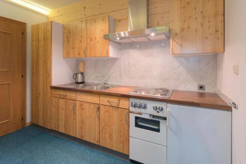 a kitchen with wooden cabinets and a white stove top oven at Das Elisabeth in Sankt Anton am Arlberg