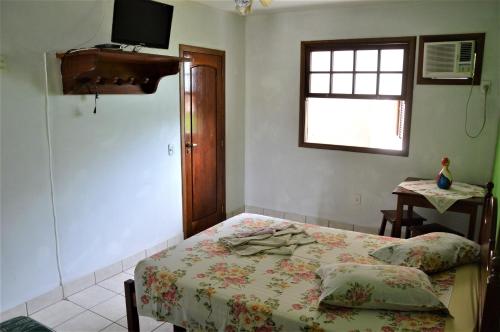 a bedroom with a bed and a window at Pousada do Imperador in Paraty