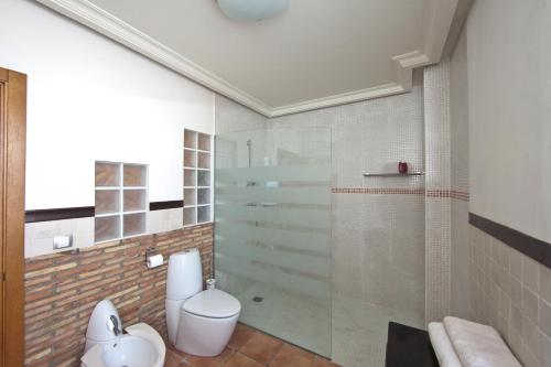 a bathroom with a toilet and a glass shower at Fileta playa Castellón in Castellón de la Plana