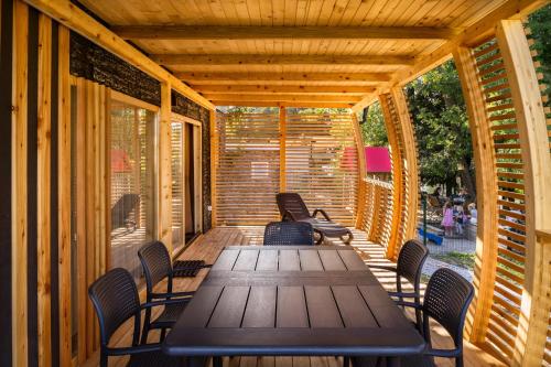 eine Holzterrasse mit einem Holztisch und Stühlen in der Unterkunft Pearl of Sava Wild Waters in Ljubljana