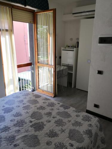 モンテロッソ・アル・マーレにあるAlbergo Al Carugioのベッドルーム1室(ベッド1台付)、スライド式ガラスドアが備わります。