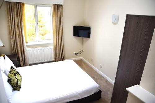 a hotel room with a bed and a window at Parkmore Hotel & Leisure Club, Sure Hotel Collection by BW in Stockton-on-Tees
