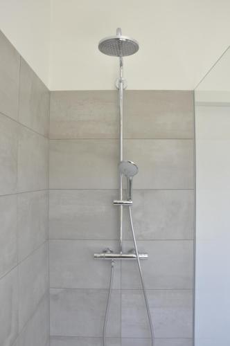 a shower with a stool in a bathroom at B&B Villa Bon Papa in De Panne