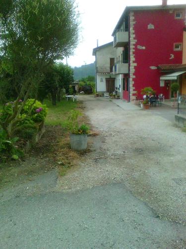 an empty street next to a red building at Agriturismo Terra E Sole in SantʼAmbrogio di Valpolicella