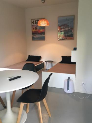 une chambre avec deux lits, une table et des chaises dans l'établissement T2 L'Escapade, à La Ciotat