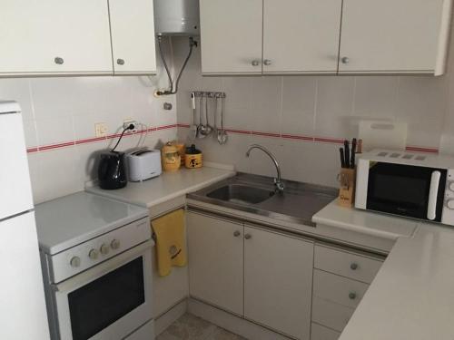 a small kitchen with a sink and a microwave at Studio w La Mata in La Mata