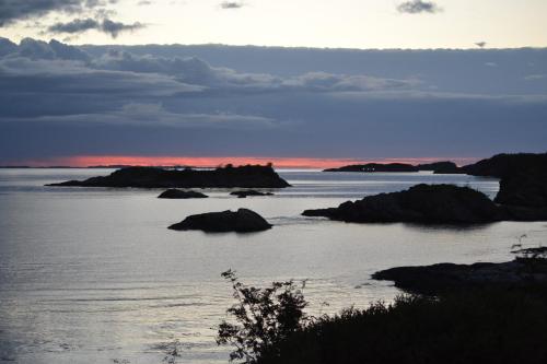 a view of the ocean with rocks in the water at Kuvågen 23 in Vågenes