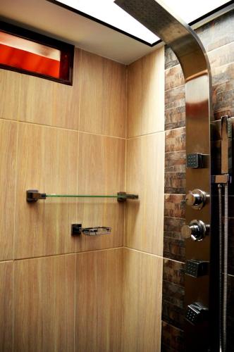 a bathroom with a shower with wooden walls at Mirador de los Cedros in Salento