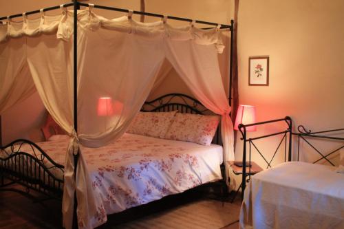 a bedroom with a bed with a canopy at La Collina dei Passeri in Pocapaglia