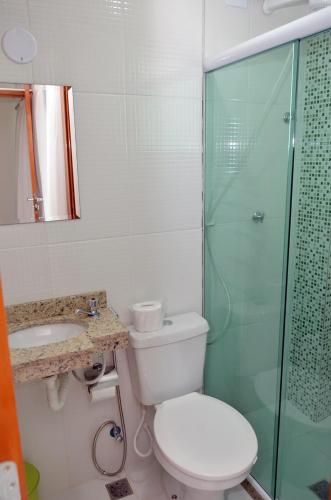 a bathroom with a toilet and a glass shower at Hostel Pontal do Duque in Rio de Janeiro