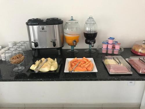 a counter with some food and drinks on it at Leati's Hotel in Marília