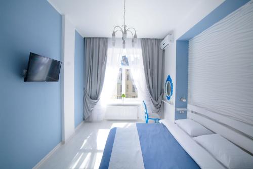 リヴィウにあるSpacious Apartment in Old City Centerの青いベッドルーム(ベッド1台、窓付)