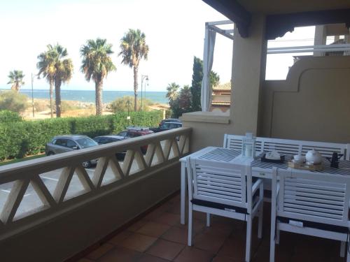 einen Balkon mit einem Tisch und Stühlen sowie Meerblick in der Unterkunft Primera Linea de Playa con Vistas al Mar in Isla Canela