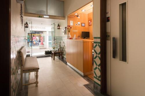a hallway of a restaurant with a counter and chairs at Hotel Santa Barbara in Beja