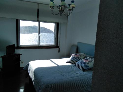 a bedroom with a bed and a window at Primera linea. Vistas al MAR in A Coruña