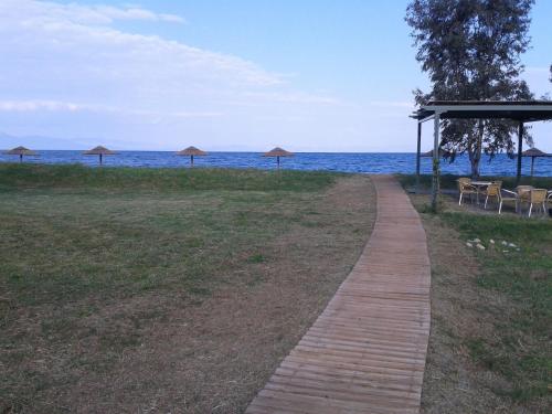 a path leading to a beach with umbrellas and the ocean at Akti Kamares in Kamáres