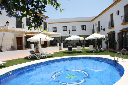 una piscina en un hotel con sillas y sombrillas en Hacienda Olontigi en Aznalcázar