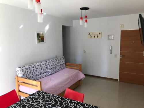 Habitación con cama, mesa y sillas. en Madryn - Roca en Puerto Madryn