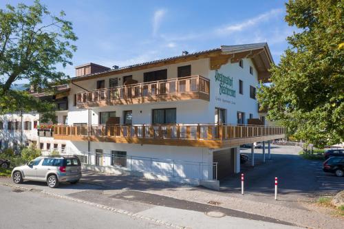 a building with a balcony on the side of it at Postgasthof Fischerwirt in Walchsee