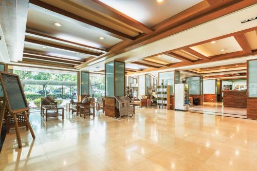 a large lobby with wooden ceilings and tables and chairs at Green Residence Ayutthaya - SHA Certified in Phra Nakhon Si Ayutthaya