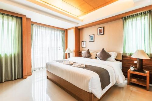um quarto com uma cama grande e janelas em Green Residence Ayutthaya - SHA Certified em Phra Nakhon Si Ayutthaya