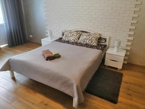 1 dormitorio con 1 cama grande y una pared de ladrillo blanco en Apartment "Provence" en Chernihiv