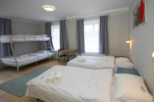 a room with three beds and a bunk bed at Willa Park Apartamenty in Olsztyn