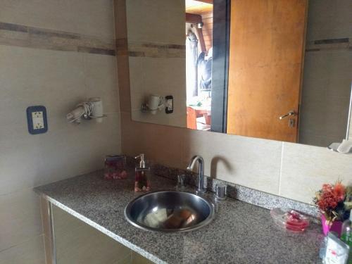 a bathroom counter with a sink and a mirror at Siete Colores, pileclimatiz in Villa Ventana