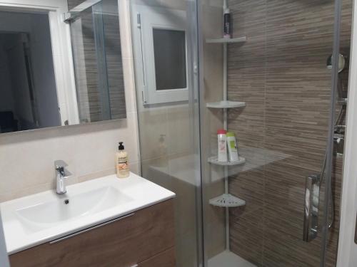 ビナロスにあるVinaròs junto al marの洗面台と鏡付きシャワーを備えたバスルーム