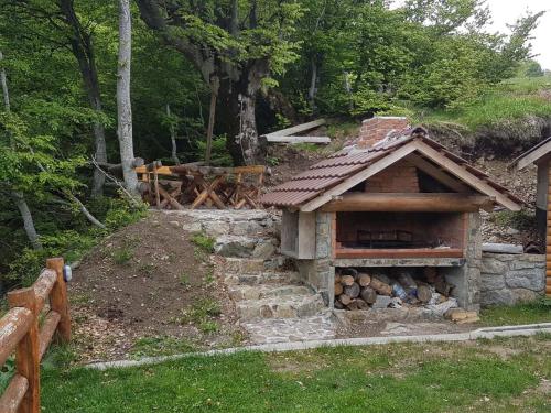a building with a pile of logs in a yard at Vila Dizdarevic Kopaonik in Kopaonik