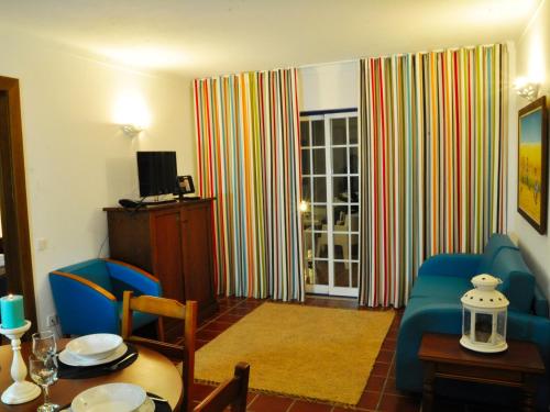 a living room with a couch and a table at Patios da Vila - Duna Parque Group in Vila Nova de Milfontes