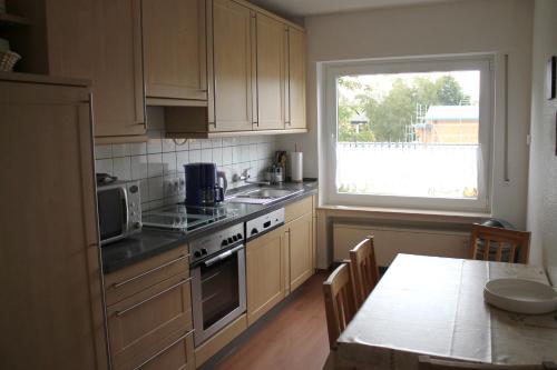 a kitchen with white cabinets and a table and a window at Ferienwohnung Baum in Winterberg in Winterberg