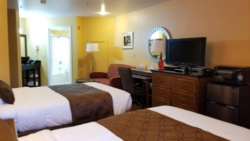 a hotel room with two beds and a flat screen tv at Dew Drop Inn in Forks