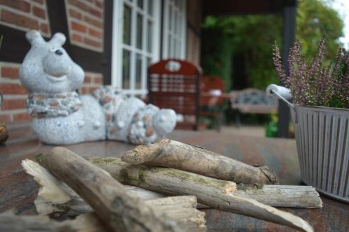 a table with logs and a statue of a dog on it at Landhaus Zum Heidewanderer mit THERMEplus in Bad Bevensen