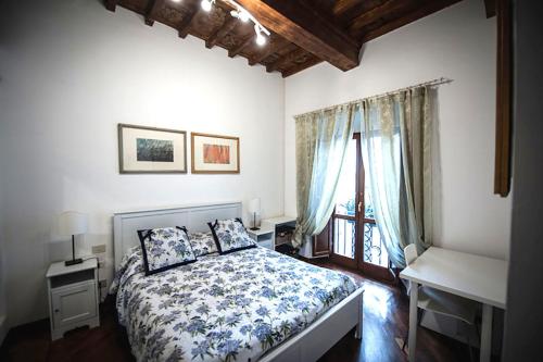 um quarto com uma cama, uma secretária e uma janela em Luxury central flat river view em Florença