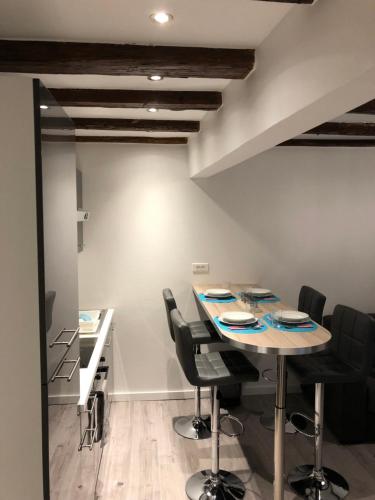 une salle à manger avec une table et des chaises noires dans l'établissement Gîte centre historique Colmar, à Colmar