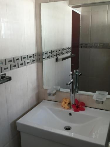 a white bathroom with a sink and a mirror at Holiday Hire Fiji in Lautoka