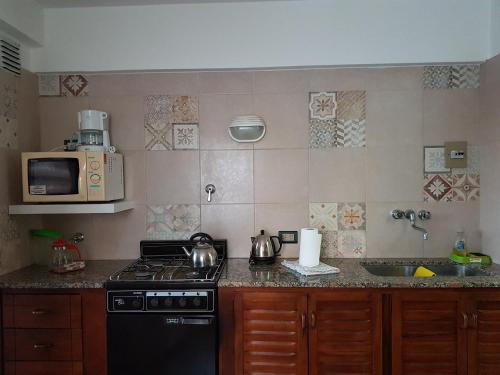 a kitchen with a stove and a microwave at Club Sol Mar Del Plata in Mar del Plata