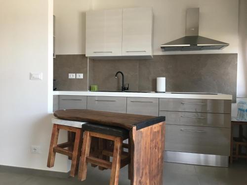 uma cozinha com armários brancos e um balcão de madeira em Attico Valentino Cellini em Turim