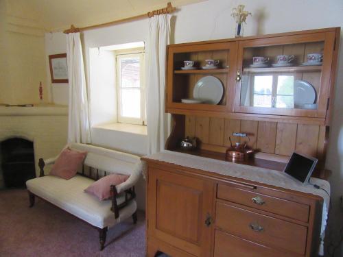 Fernbrook Cottage في Marrangaroo: غرفة بها خزانة وكرسي ونافذة