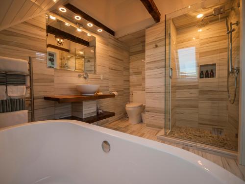ein großes Bad mit einer Badewanne und einer Dusche in der Unterkunft Auberge Thon Jaune - Yellow Tuna in Wedgeport